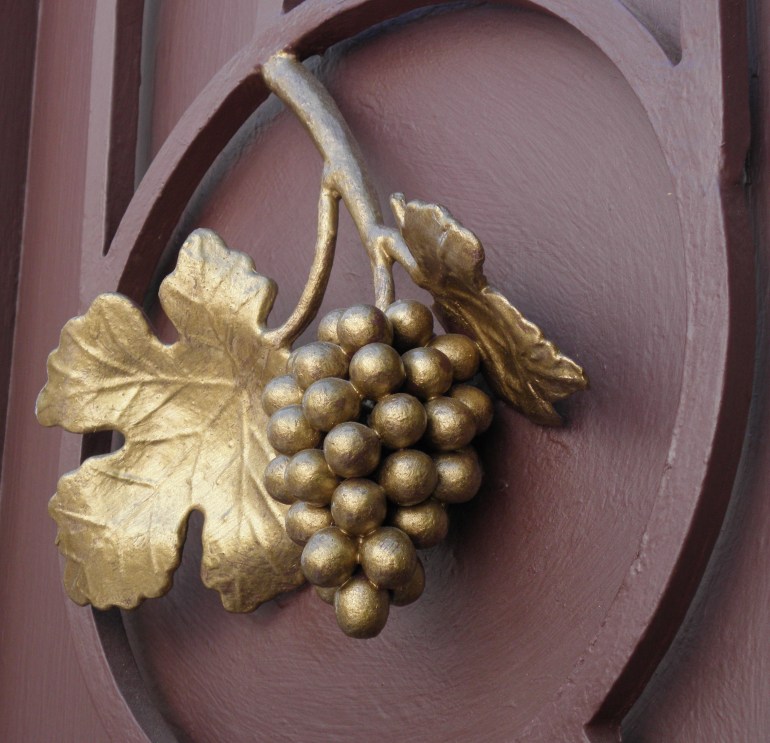 Grape leaf and bunch of grapes gilded on a church door in Israel